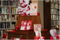desk in a library setting exhibiting books wrapped in valentine's day paper
